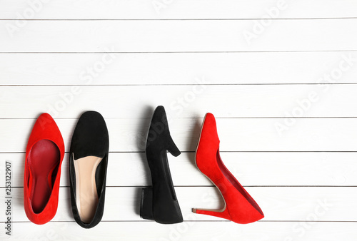 Flat lay composition with stylish shoes and space for text on wooden background