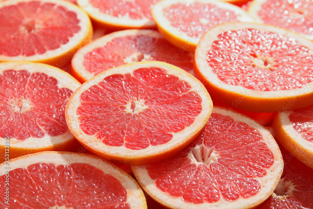 Many sliced fresh ripe grapefruits as background, closeup Many sliced fresh ripe grapefruits as background, closeup