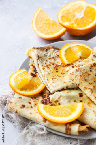Crepes with orange, honey and natural yogurt or sour cream. Thin pancakes. Light concrete background. Copy space.