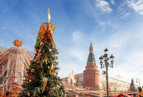 Manezhnaya Square in the center of Moscow, decorated with festive symbols of the Shrovetide in the form of the sun, colorful ribbons and garlands. Trade rows stand against the Kremlin walls .