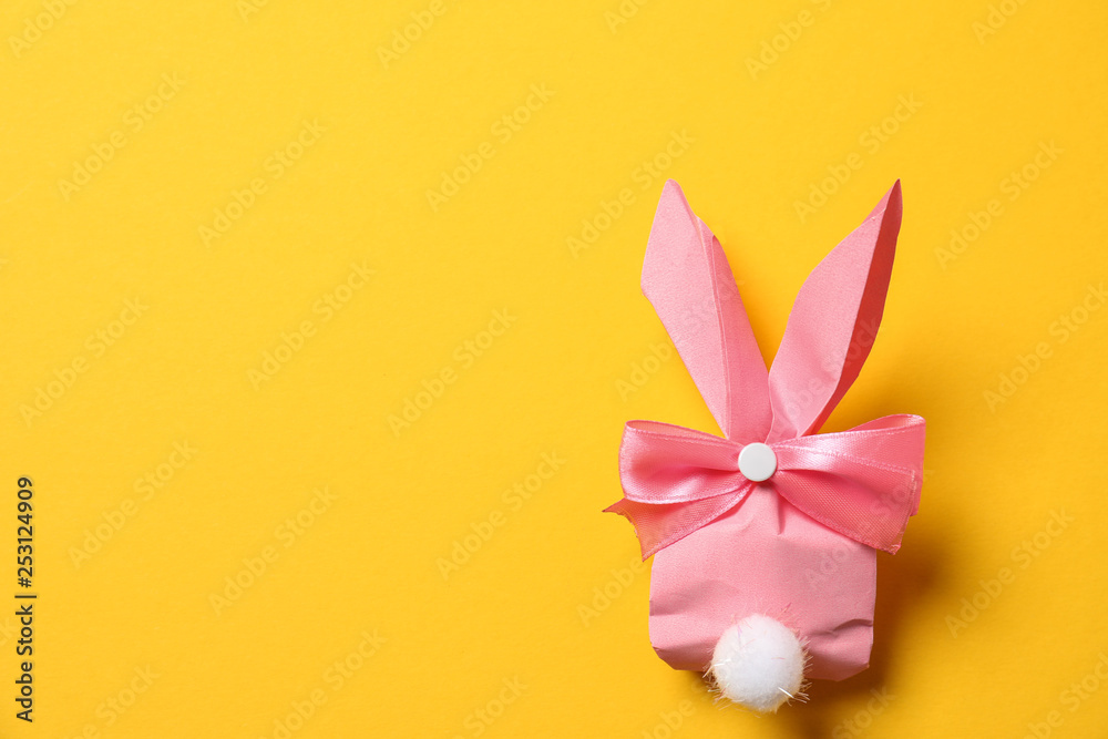 Creative Easter bunny gift bag on color background, top view with space for text