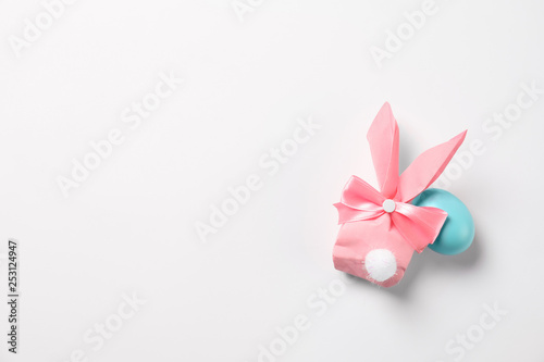 Easter bunny gift bag and dyed egg on white background  top view