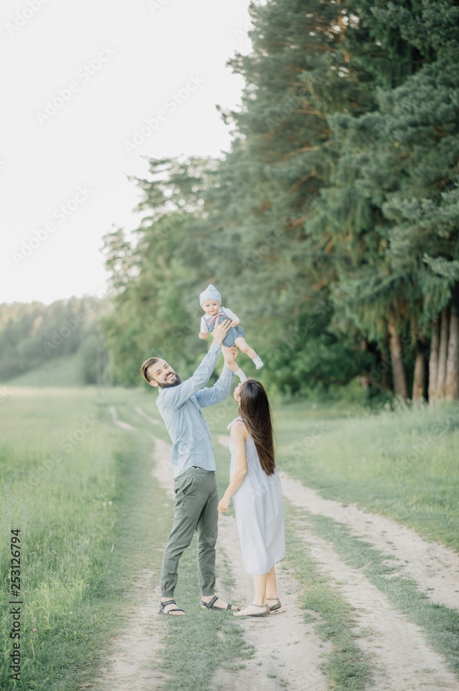 Fototapeta premium portrait of father and child. A stylish father with a beard keeps on his arms a child, a little girl, they embrace and smile, rejoice and have fun. Happy Father's Day