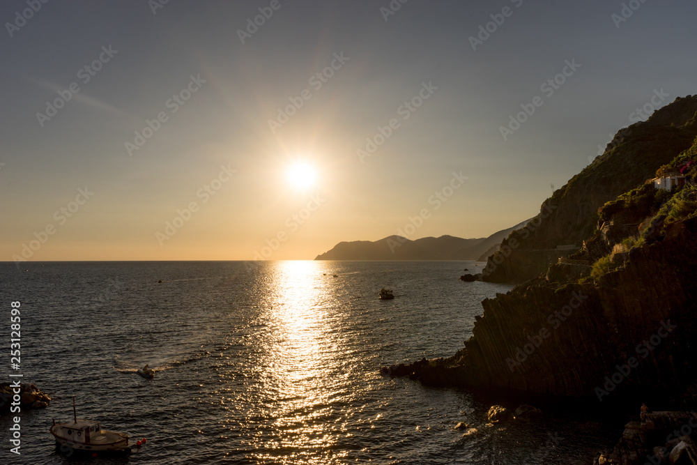 Golden sunset at the cliff at the Italian Riviera in the Village of Riomaggiore, Cinque Terre, Italy