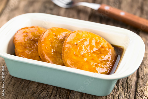 Chilean Sopaipilla pasada deep-fried pastry covered in chancaca cane sugar sauce, a popular snack in autumn and winter (Selective Focus, Focus one third into the right sopaipilla) photo