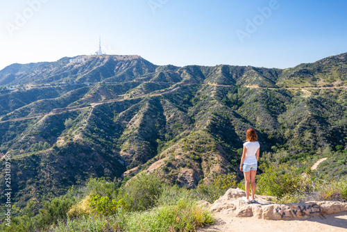 Young woman looking at the Hollywood sign in Los Angeles, California, USA. Dreaming about going to Hollywood. .