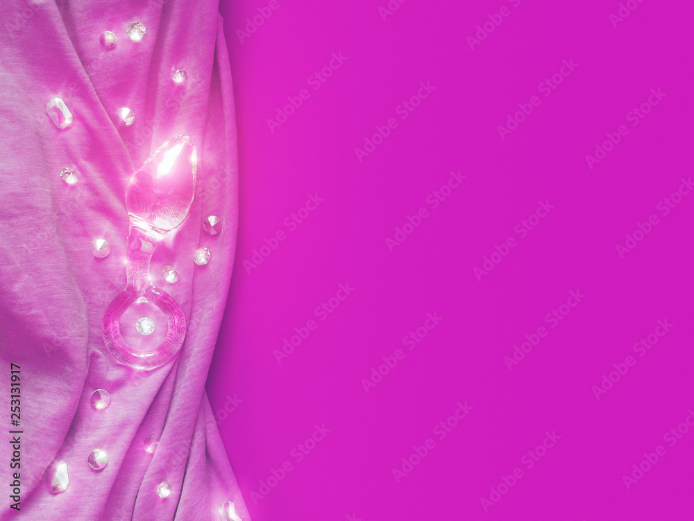The glass sex toy (butt plug) is on a fuchsia fabric. Rhinestones are located nearby. The glass sex toy (butt plug) is on a fuchsia fabric. Rhinestones are located nearby.