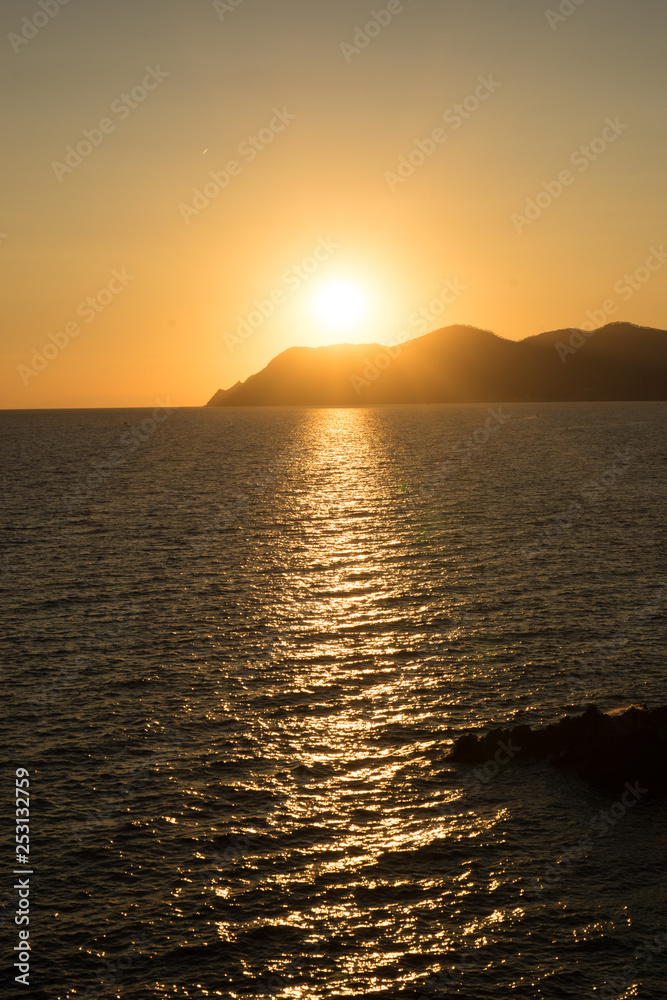 Golden sunset at the cliff at the Italian Riviera in the Village of Riomaggiore, Cinque Terre, Italy