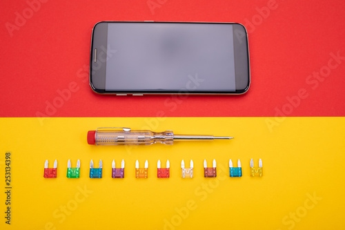 Set of electrical tool with black smartphone on colorful background photo