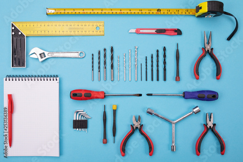 set of metalwork tools with notebook and pen on colorful background photo