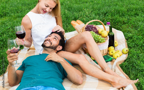 Adult man is lying on the lap of girlfriend in time picnic in the park.