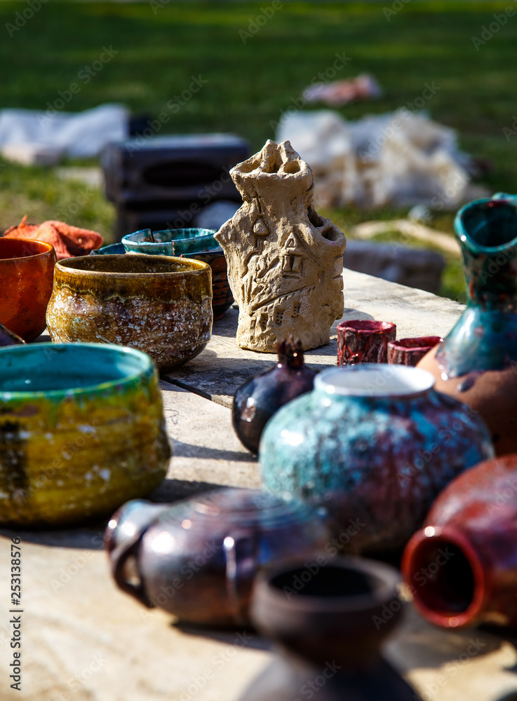 Background from small ceramic multicolored jugs and cups.