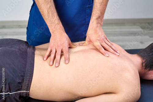 Physiotherapist giving a back massage. Chiropractic, osteopathy, manual therapy, acupressure