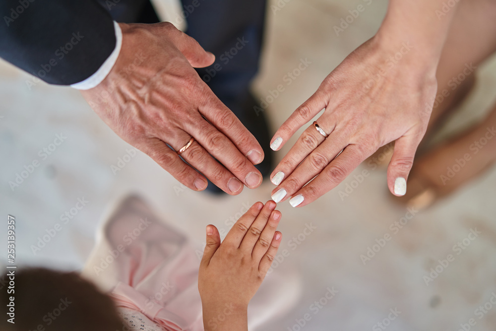 Father, mother and daughter hold hands together Father, mother and daughter hold hands together