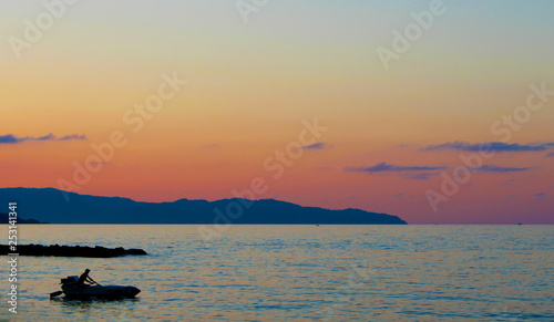 Black sea coast, fishers boat silhouette at sunset