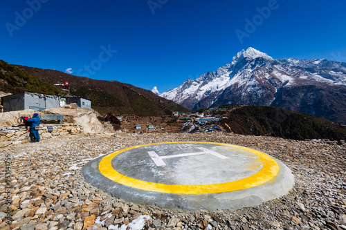 Helipad. Everest trekking. In the background, the village of Namche Bazaar. Left is a tourist. photo