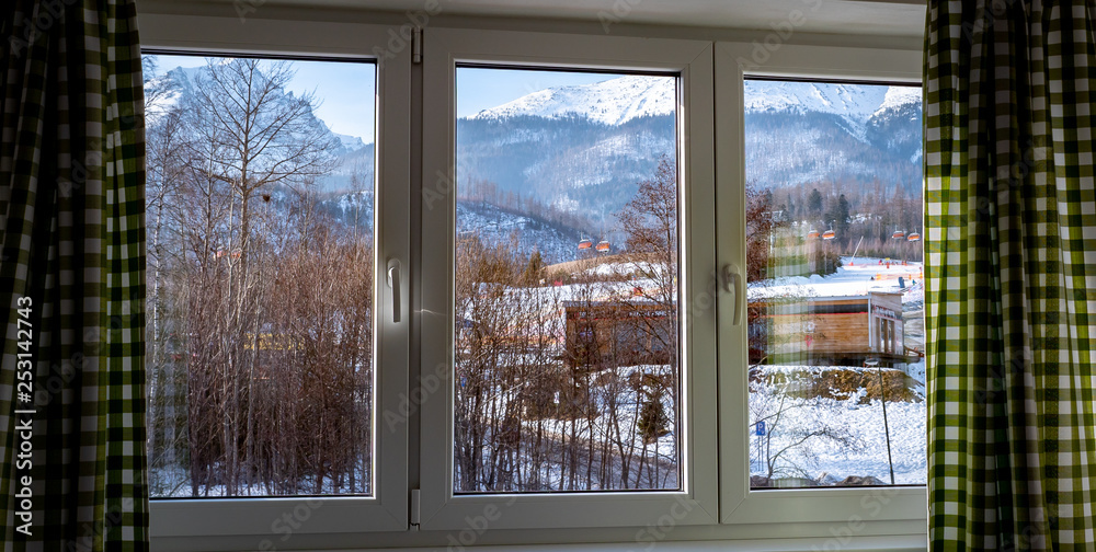 Beautiful view through window at the Tatry mountains from the hotel in Tatrzanska Lomnica, Slovakia during winter season.
