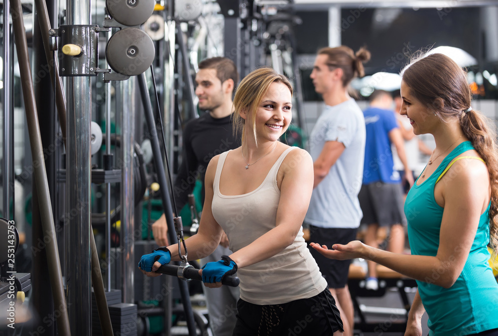 Fototapeta premium Adults having strength training under coach control in gym