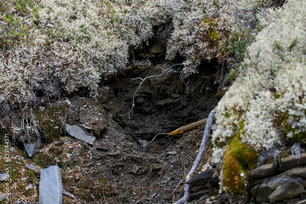 Dug pit in the ground for sampling for gold Dug pit in the ground for sampling for gold