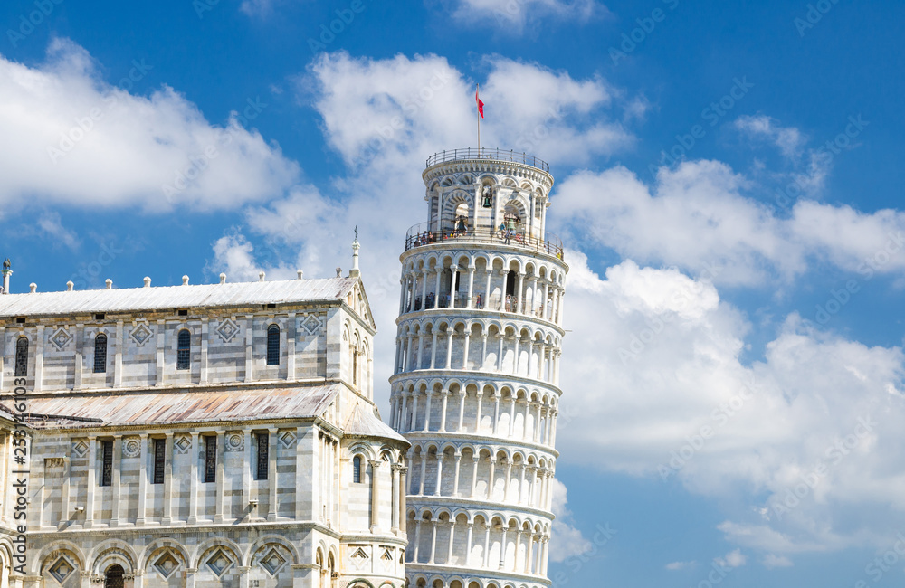 Pisa Cathedral Duomo Cattedrale and Leaning Tower Torre on Piazza del Miracoli square, blue sky with white clouds background in sunny day, Tuscany, Italy