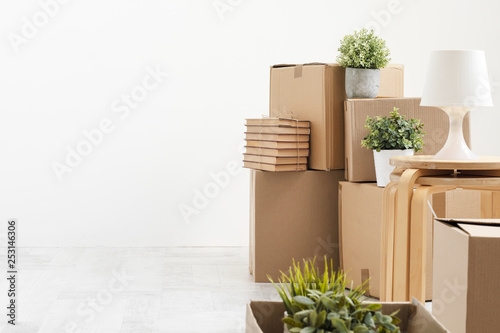 Foto Cardboard boxes with things are stacked on the floor against the background of a white wall close up