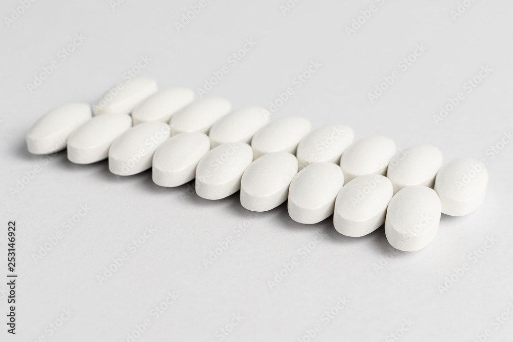 Close up of two parallel lines on white pills on white background
