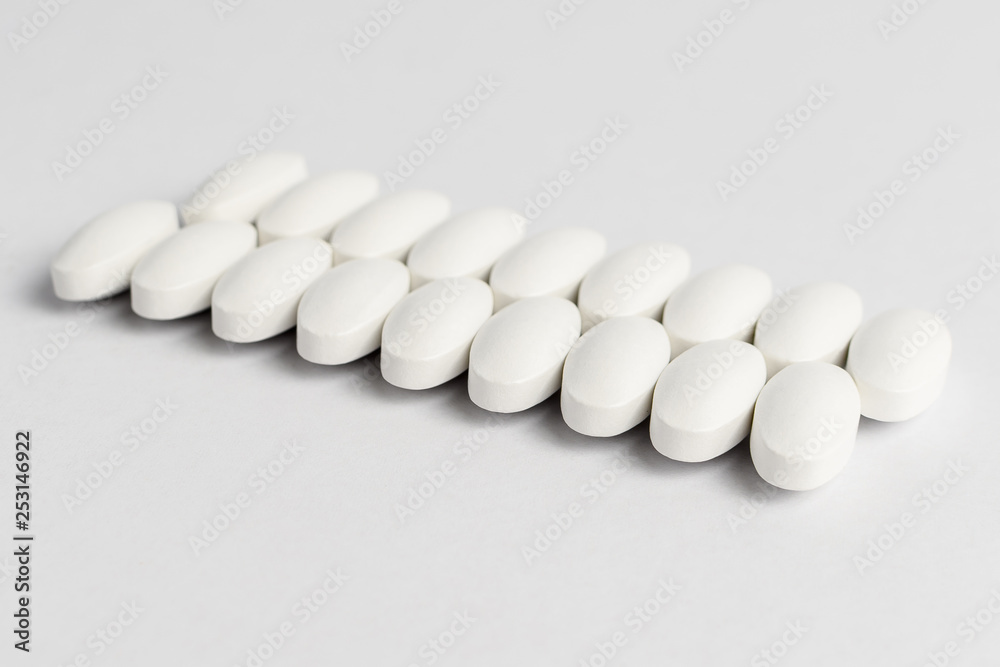 Close up of two parallel lines on white pills on white background Close up of two parallel lines on white pills on white background