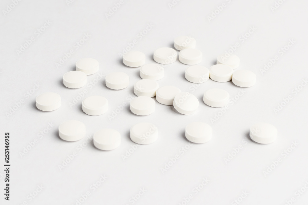 Side view of a group of white pills on white background, in random order Side view of a group of white pills on white background, in random order