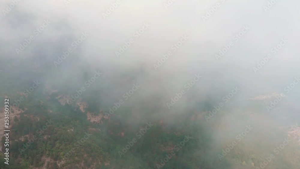 Misty forest, drone flying through the clouds at the top of mountain, aerial shot Misty forest, drone flying through the clouds at the top of mountain, aerial shot