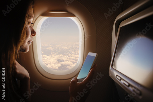 Woman in airplane using mobile phone