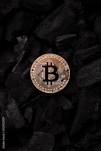 Bitcoin mining concept. Bitcoin cuurency on charcoal photo