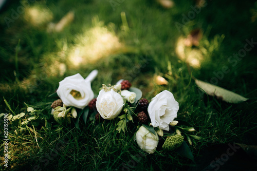 wedding boutonniere for the groom and bridesmaids on the grass photo