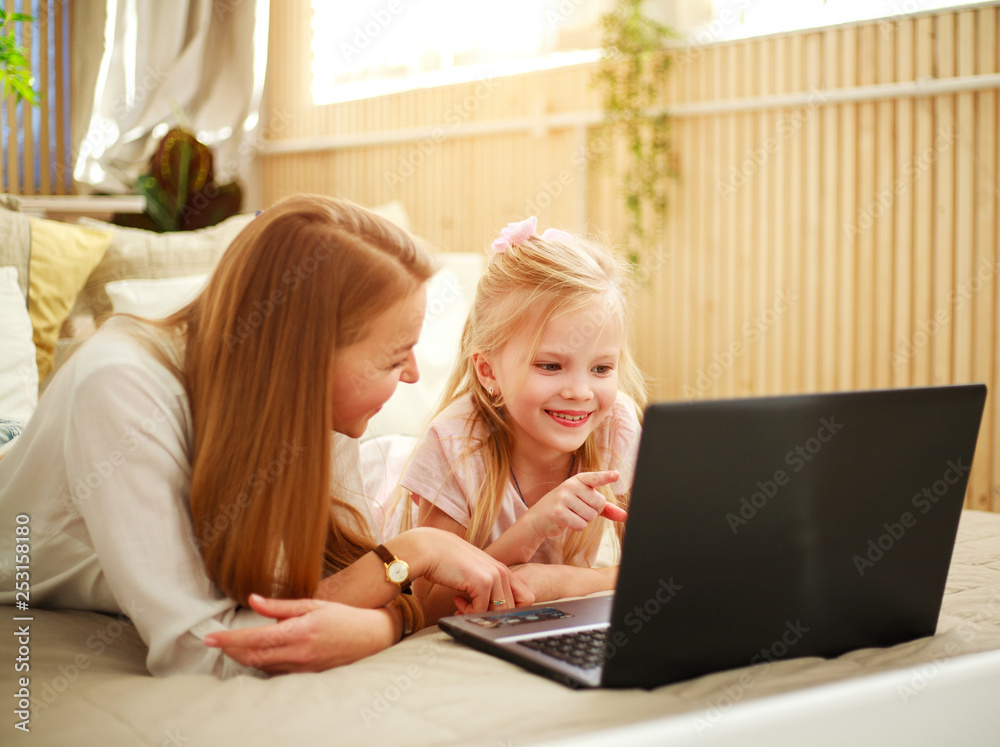 Happy family mother with daughter using computer laptop at home, modern lifestyle Happy family mother with daughter using computer laptop at home, modern lifestyle