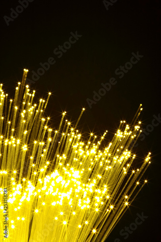 Yellow fibre optic strands glowing against a black background