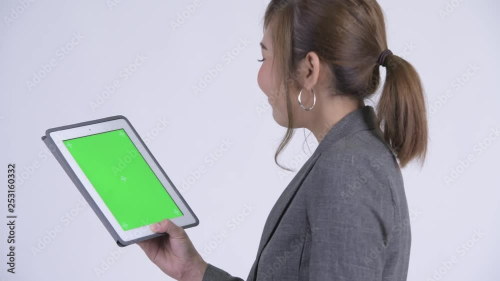 Closeup rear view of young happy Asian businesswoman using digital tablet Closeup rear view of young happy Asian businesswoman using digital tablet