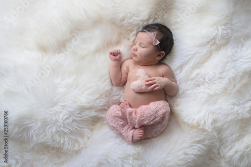Sleeping Newborn Baby Girl with Heart Shaped Pillow photo