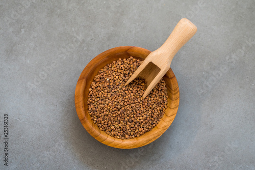 Buckwheat in a wooden bowl ongray stone background photo