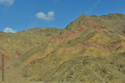 Beautiful colorful rocks of the Sinai mountains and blue sky with white clouds in sunny day. Mountain landscape. 