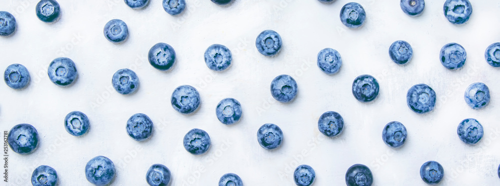 Food background with fresh blue blueberries on gray table, top view - obrazy, fototapety, plakaty 