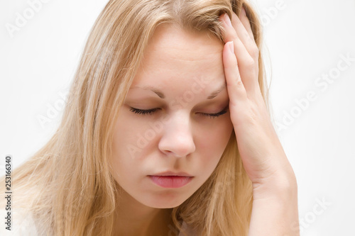 Young, adult blonde lady trying to calm down. Lonely, grieving, nervous woman touching head. Memory disorder. Suffering from burnout or other psychological problems. Women's issues. Face close up.