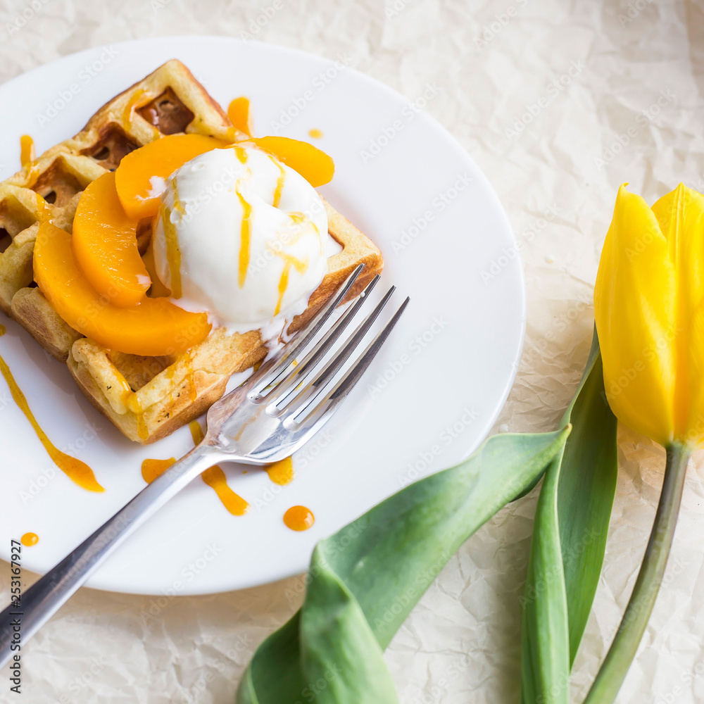Beautiful festive Belgian waffle breakfast next to a yellow tulip Beautiful festive Belgian waffle breakfast next to a yellow tulip