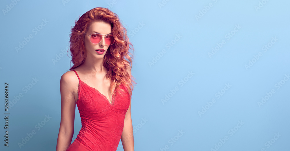 Sensual Curly Redhead woman with make up wearing Stylish fashionable, Coral bodysuit. Beautiful sexy Lady in Trendy Attire, fashion Sunglasses. Female model in Studio. Banner Sensual Curly Redhead woman with make up wearing Stylish fashionable, Coral bodysuit. Beautiful sexy Lady in Trendy Attire, fashion Sunglasses. Female model in Studio. Banner