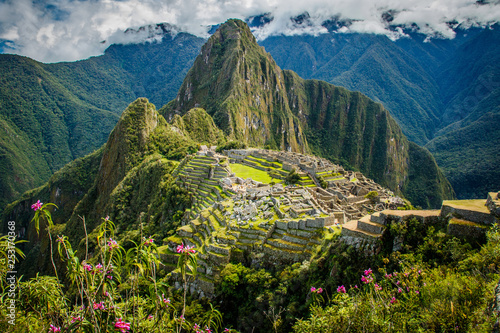 Famous view of Machu Picchu city in pink flowers, Peru photo