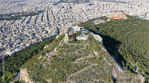 Aerial birds eye view photo taken by drone of Lycabettus hill and iconic Saint George chapel on top, Athens historic centre, Attica, Greece photo