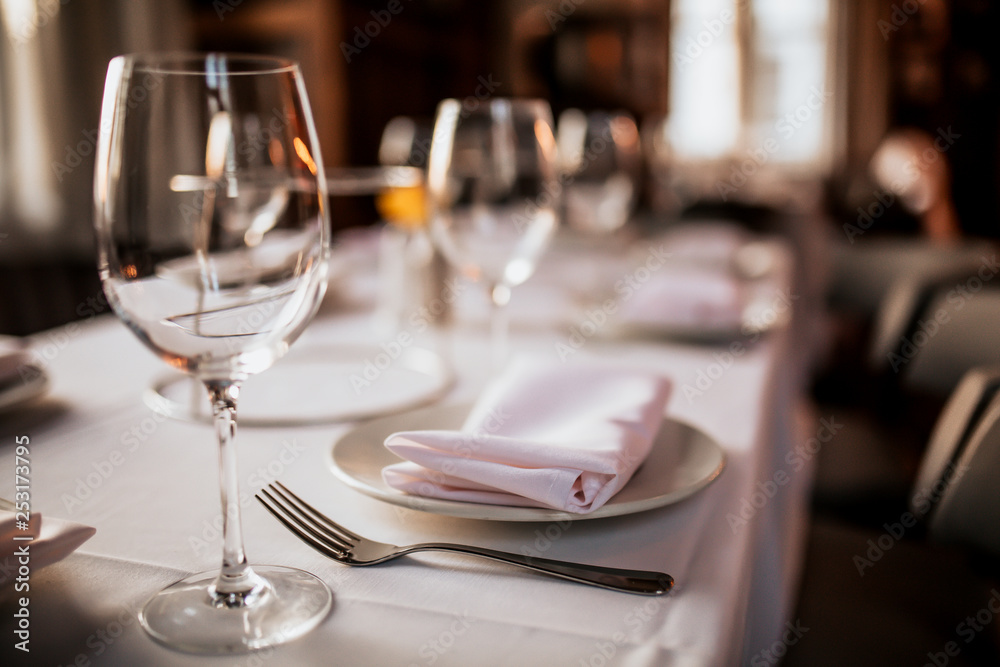 A close up shot of a restaurant table set up with tableware and wine glass. Concept of dining, hospitality and catering. Horizontal image with free space for text. A close up shot of a restaurant table set up with tableware and wine glass. Concept of dining, hospitality and catering. Horizontal image with free space for text.
