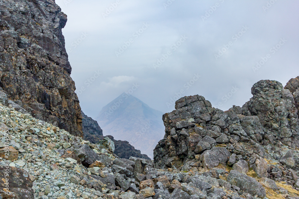 A rocky mountain view with a far away summit and altitude white clouds A rocky mountain view with a far away summit and altitude white clouds