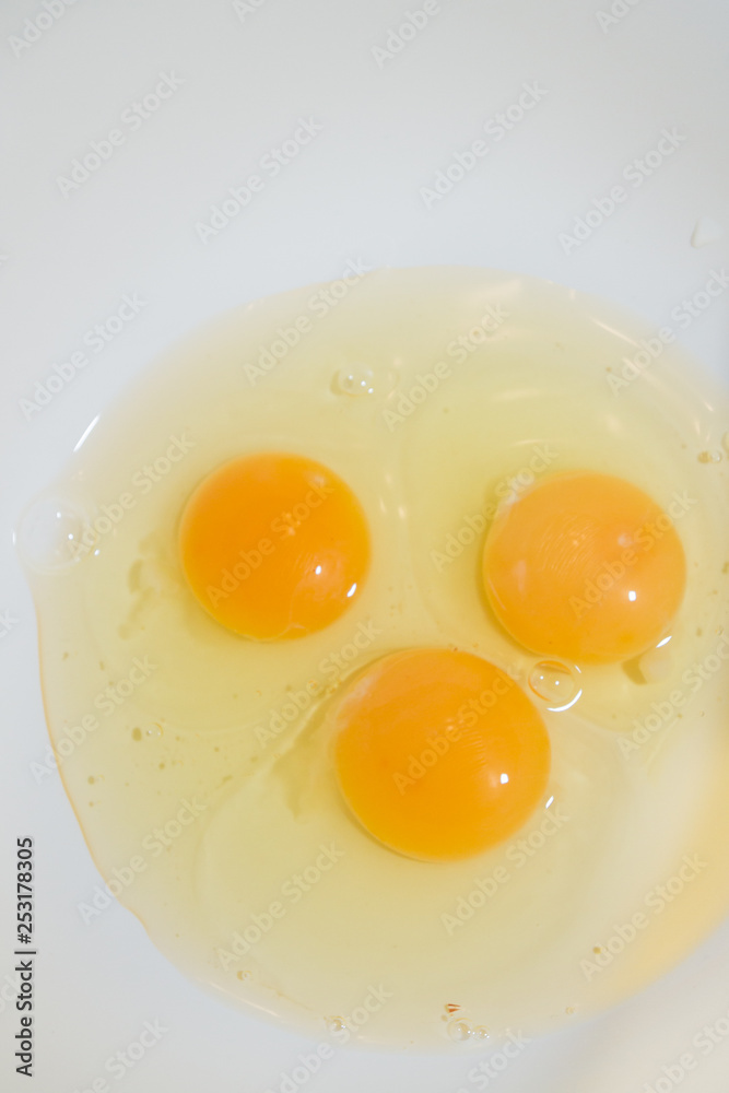 Three broken chicken eggs in a white mixing bowl Three broken chicken eggs in a white mixing bowl