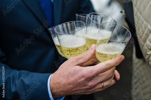 A man holds many glasses of champagne, a holiday. wedding