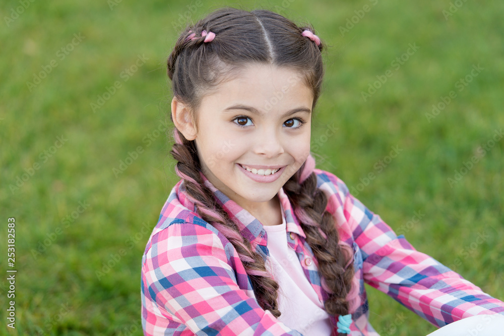 Charming smile. Fashion trend. Salon and hair care. Girl smile face outdoors. Pleasant walk in park. Smile and joy. Fashionable hairstyle for kids. Girl small kid with fashionable braids hairstyle Charming smile. Fashion trend. Salon and hair care. Girl smile face outdoors. Pleasant walk in park. Smile and joy. Fashionable hairstyle for kids. Girl small kid with fashionable braids hairstyle
