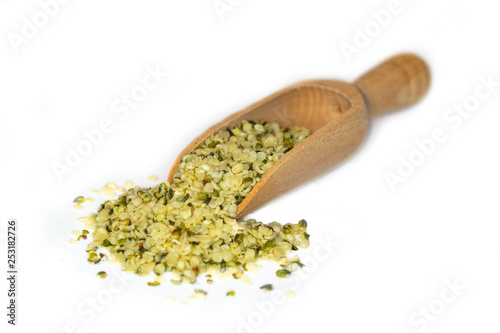 Closeup of hulled hemp seeds, a plant based source of omega-3 fatty acids, presented on a small wooden scoop photo